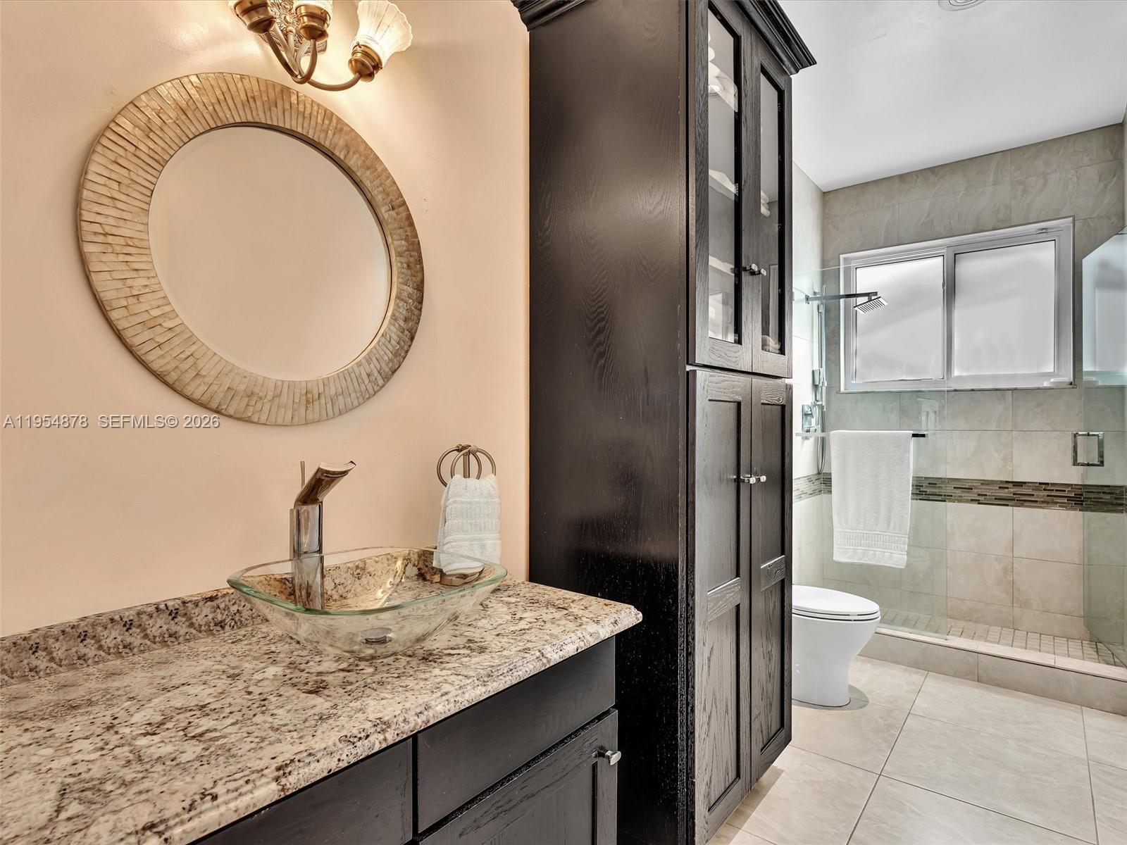 900 Spoonbill Circle Weston, FL 33326 - Photo 38 of 51 a bathroom with a granite countertop sink a toilet and mirror