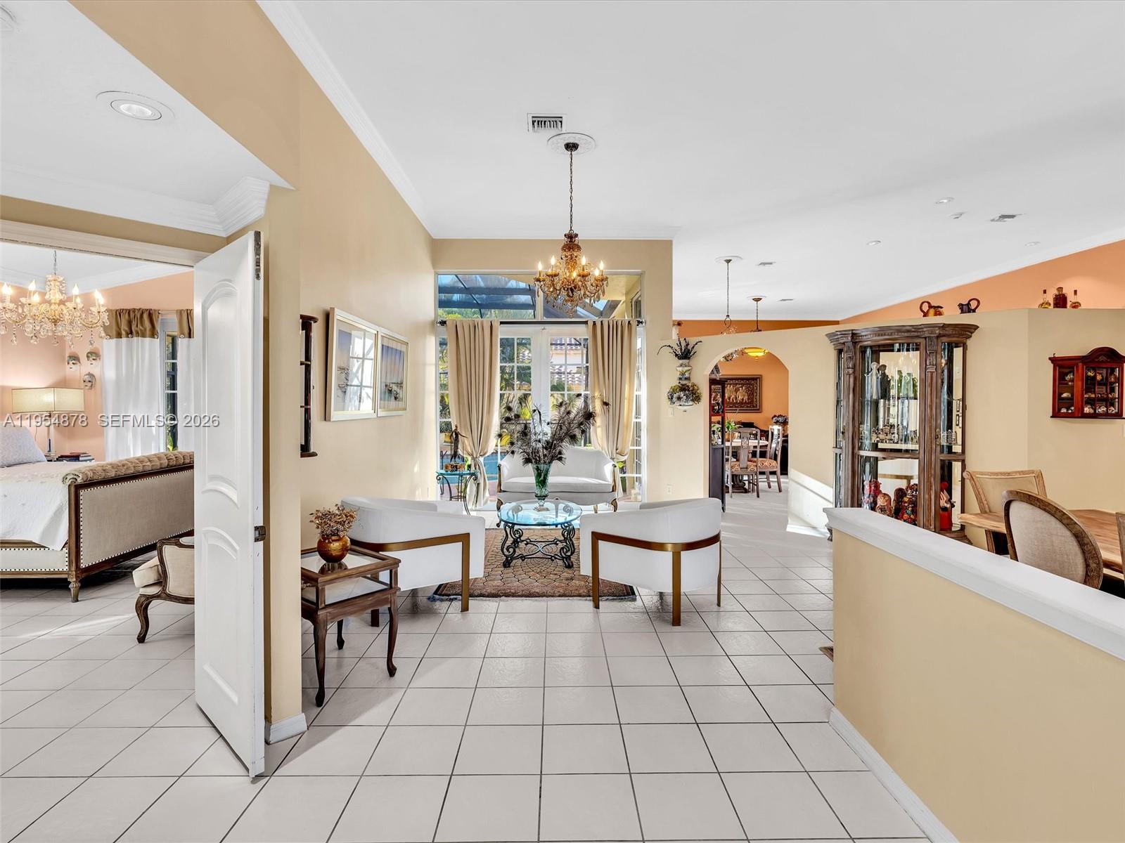 900 Spoonbill Circle Weston, FL 33326 - Photo 4 of 51 a living room with furniture a rug and a chandelier
