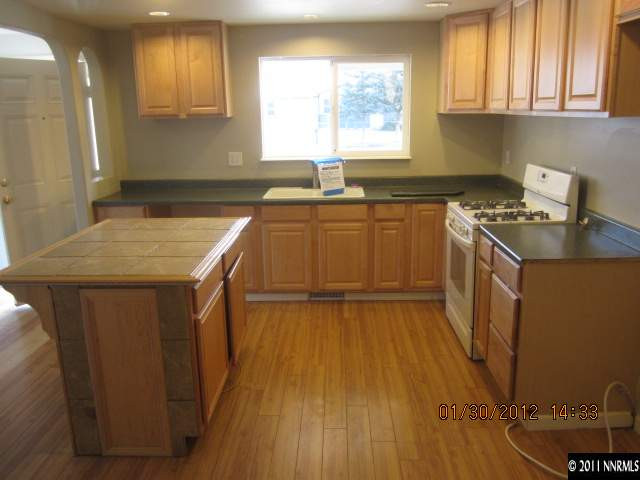 9375 Fremont Way Reno, NV 89506 - Photo 7 of 12 a kitchen with a sink a stove cabinets and wooden floor