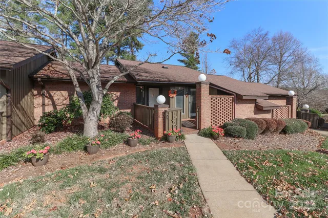 a view of a house with a small yard and potted plants