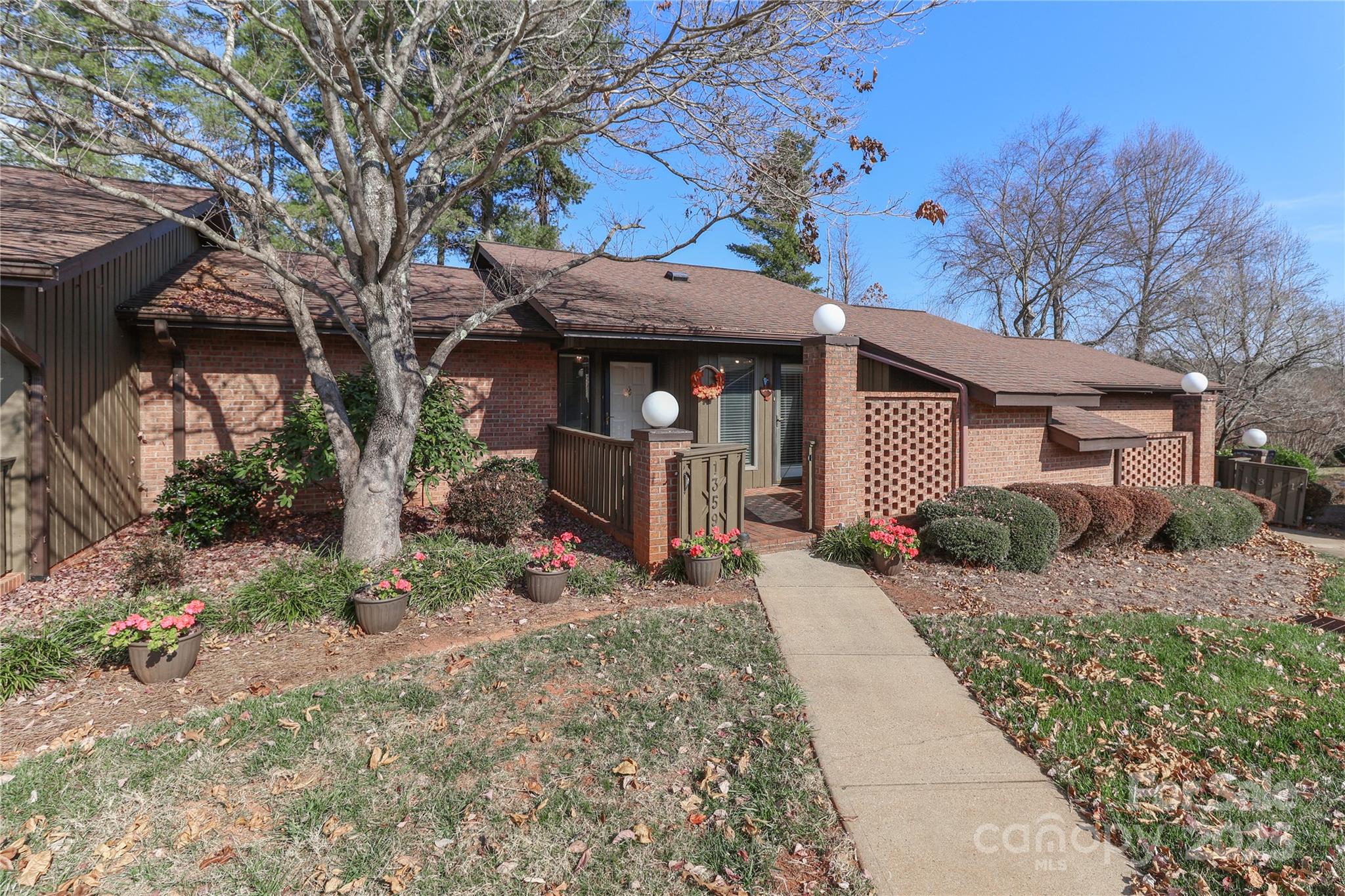 a view of a house with a small yard and potted plants