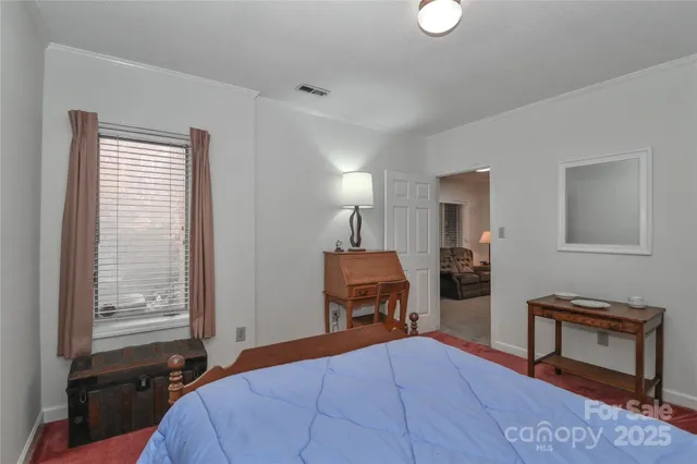 a bedroom with a bed and a lamp on dresser