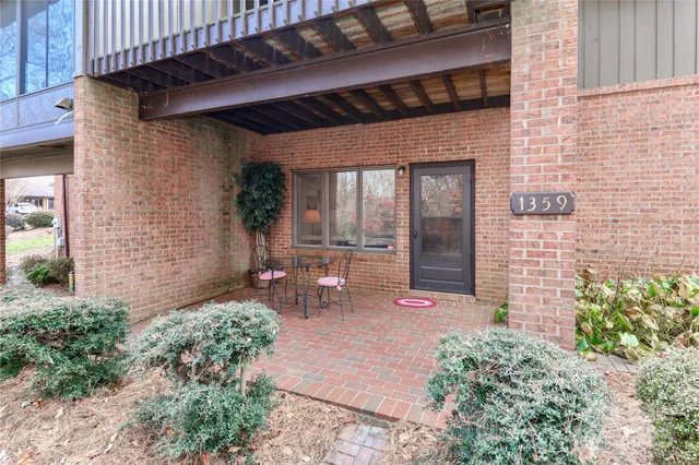 a view of a chair and table in backyard of the house
