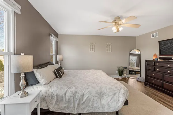 a bedroom with a bed and wooden floor