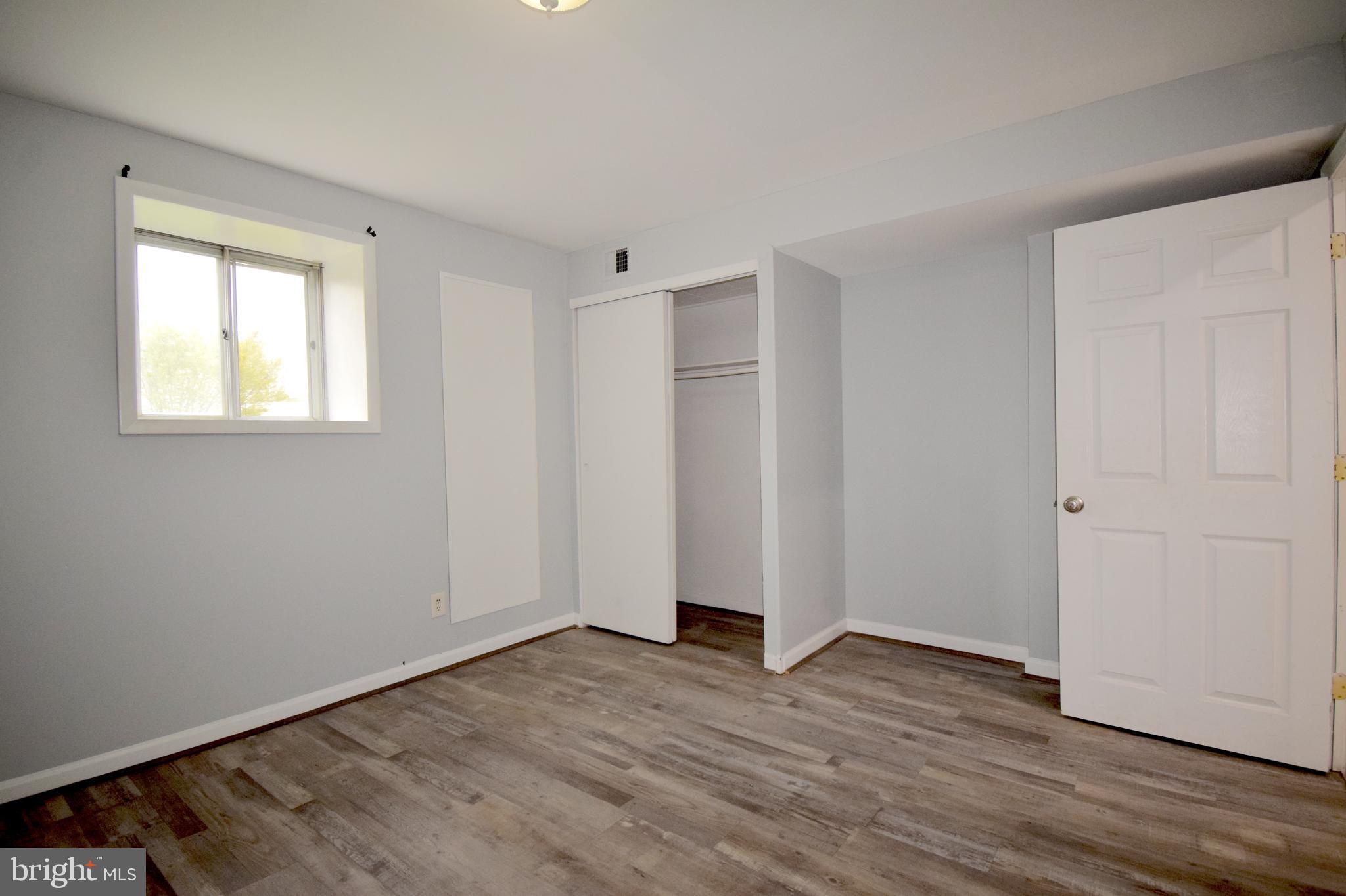 14017 Adkins Road Laurel, MD 20708 - Photo 14 of 18 a view of an empty room with wooden floor and a window