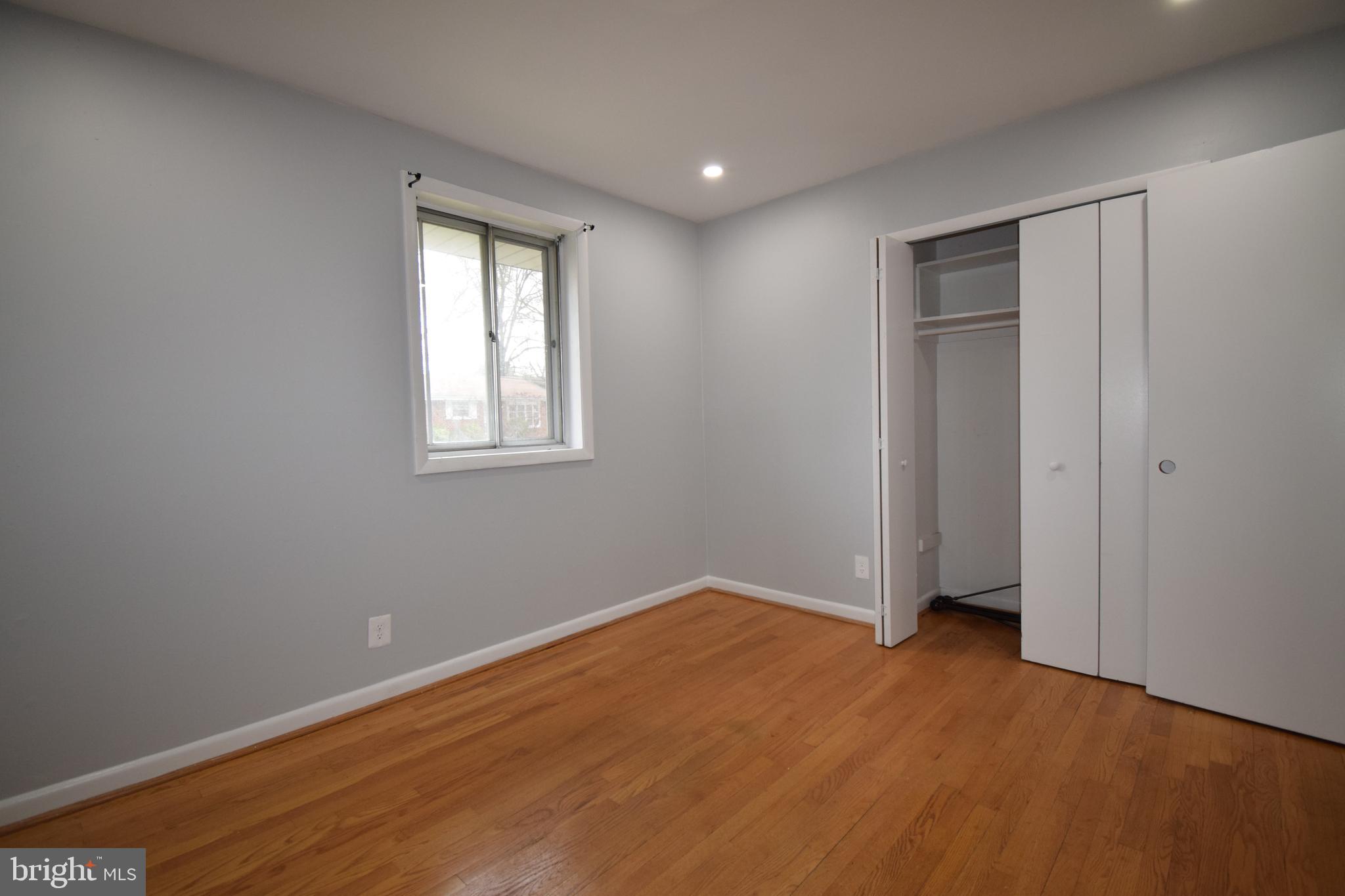 14017 Adkins Road Laurel, MD 20708 - Photo 5 of 18 a view of an empty room with wooden floor and a window
