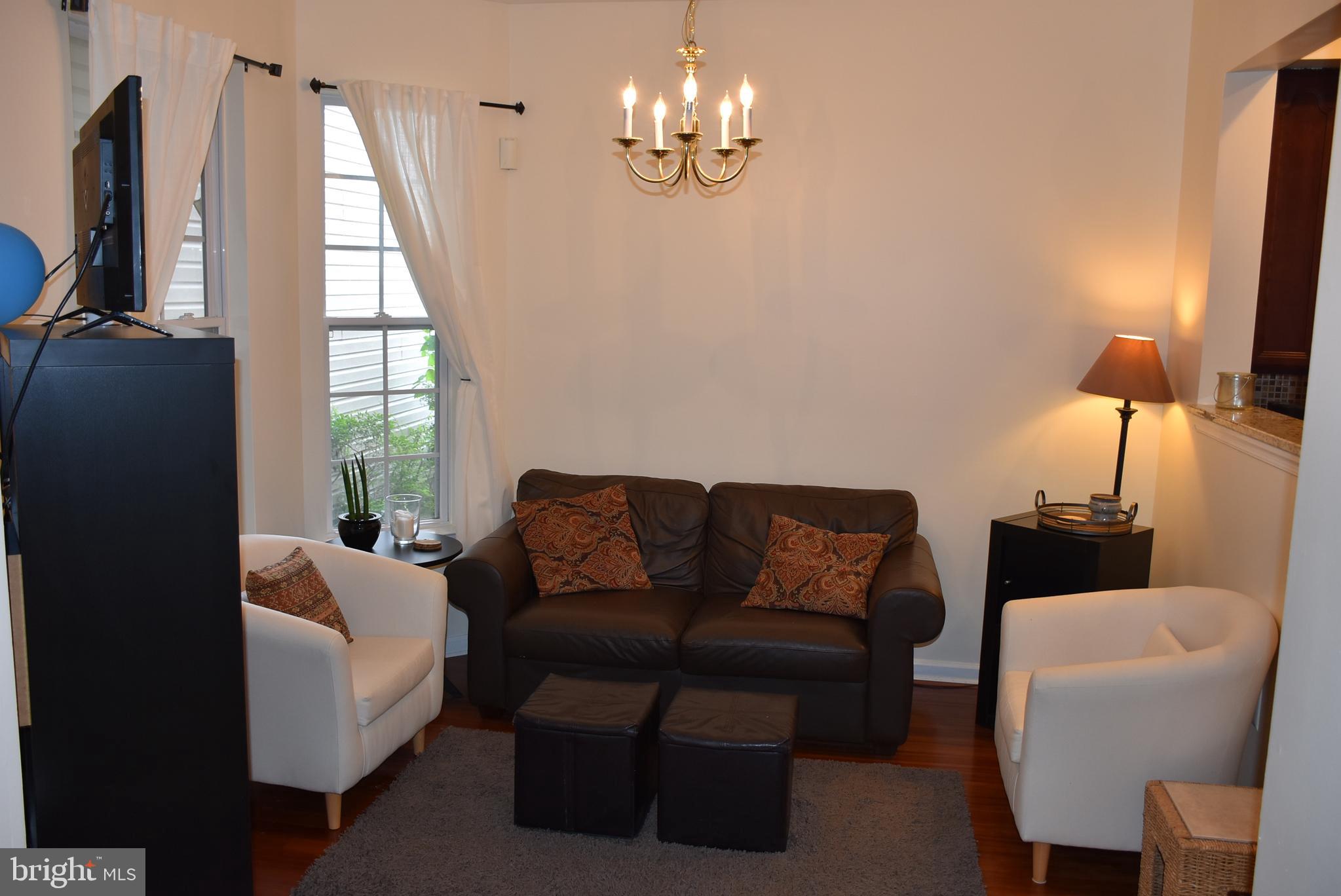 65 Heath Court Pennington, NJ 08534 - Photo 5 of 18 a living room with furniture a flat screen tv and a large window