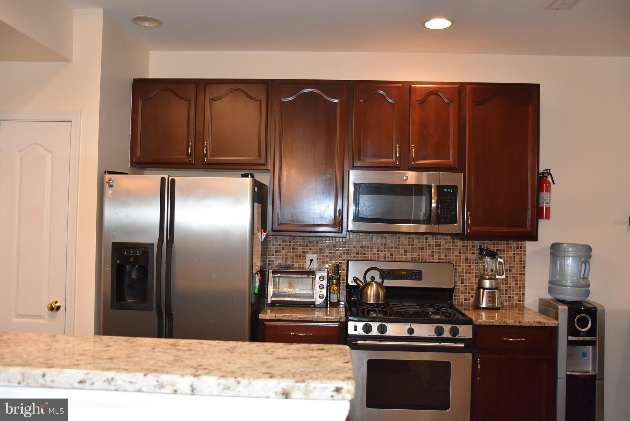 65 Heath Court Pennington, NJ 08534 - Photo 6 of 18 a kitchen with granite countertop stainless steel appliances and wooden cabinets