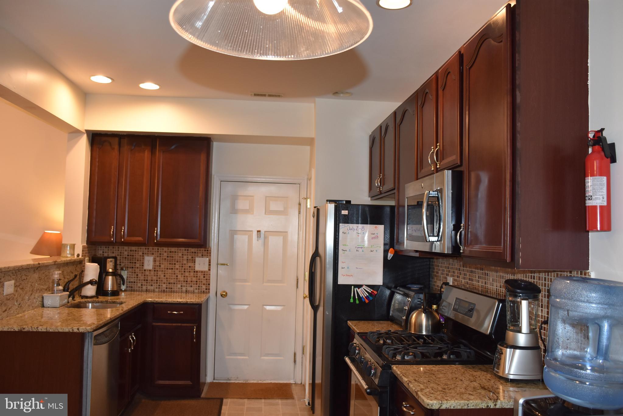 65 Heath Court Pennington, NJ 08534 - Photo 7 of 18 a kitchen with refrigerator a stove a sink and cabinets