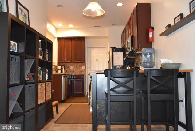 a kitchen view of a refrigerator and chairs