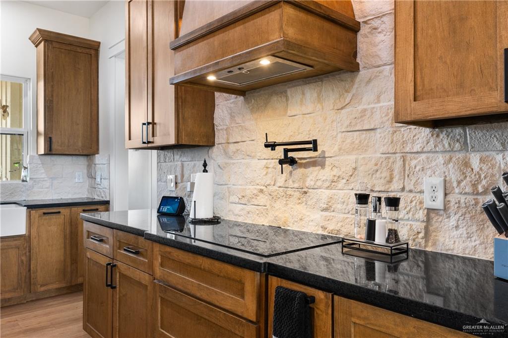23588 Beefmaster Road Monte Alto, TX 78538 - Photo 11 of 45 a kitchen with granite countertop a sink a stove and cabinets