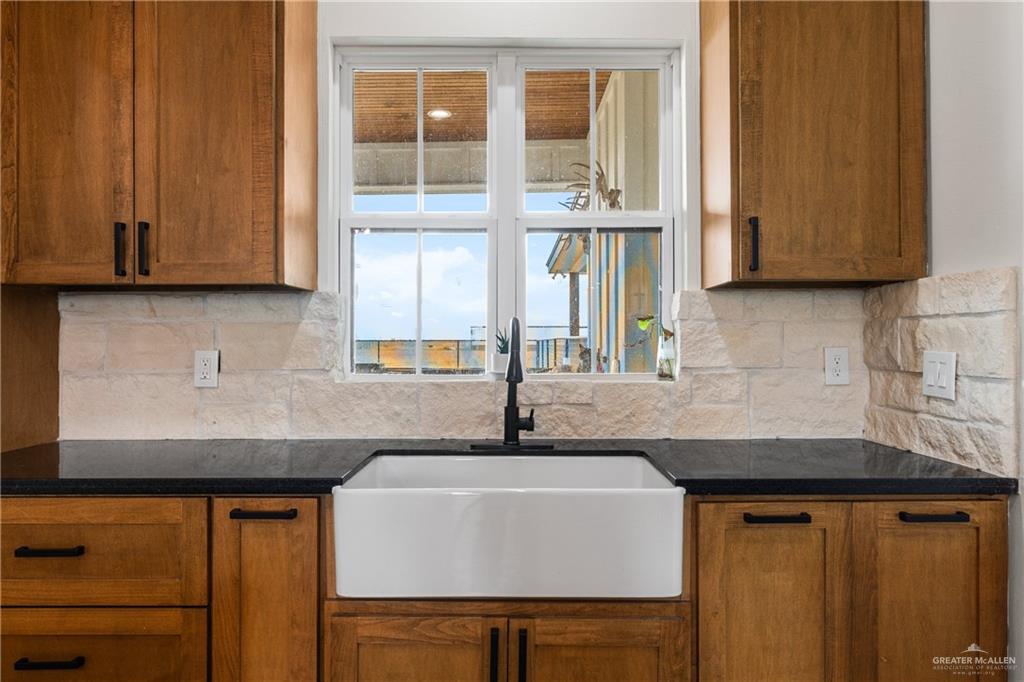 23588 Beefmaster Road Monte Alto, TX 78538 - Photo 12 of 45 a kitchen with granite countertop a sink and a stove