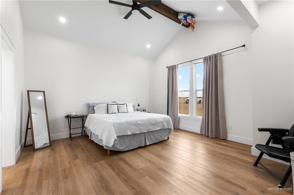 23588 Beefmaster Road Monte Alto, TX 78538 - Photo 23 of 45 a spacious bedroom with a bed and a chair