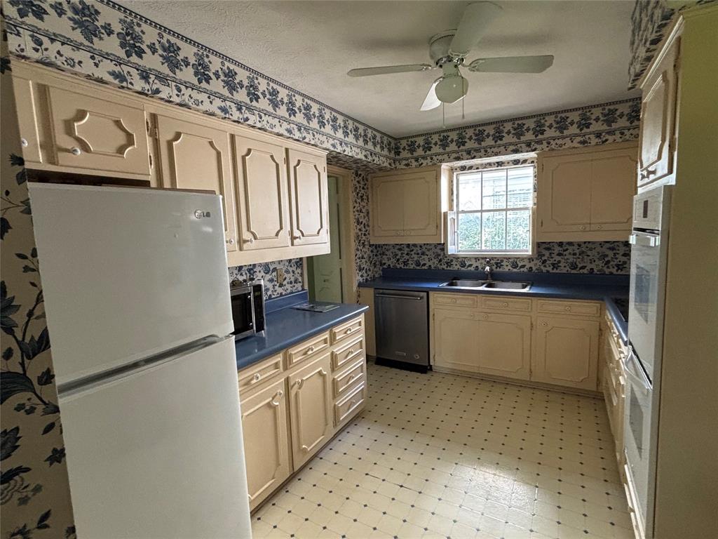 328 Ridge Crest Drive Richardson, TX 75080 - Photo 7 of 17 a kitchen with granite countertop a refrigerator a sink and white cabinets