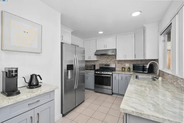a kitchen with white cabinets sink and stainless steel appliances