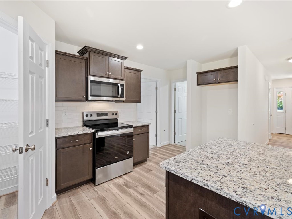 2021 Ridge Road Powhatan, VA 23139 - Photo 15 of 44 a kitchen with stainless steel appliances kitchen island granite countertop a stove refrigerator and microwave