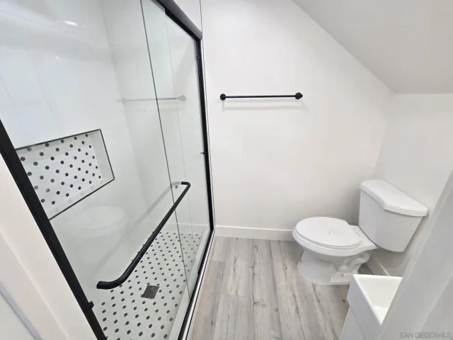 a bathroom with a toilet and a shower