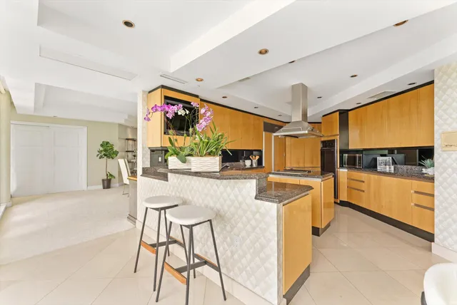 a view of a kitchen with kitchen island stainless steel appliances a stove and a large window