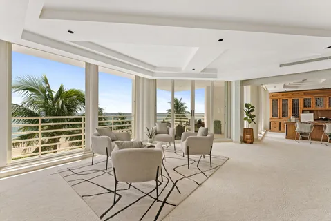 a living room with furniture and large windows