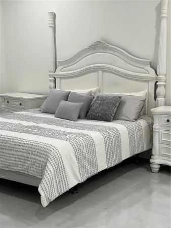 a bedroom with a bed next to a larger window