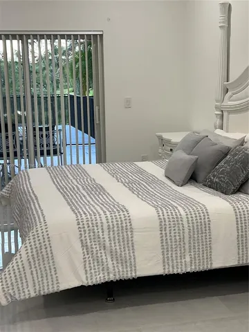 a view of a backyard with swimming pool and trees in the background