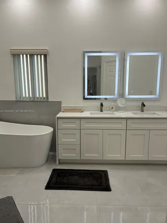 a bathroom with a bathtub sink and mirror