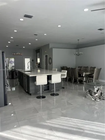 a living room with lots of furniture and view of kitchen