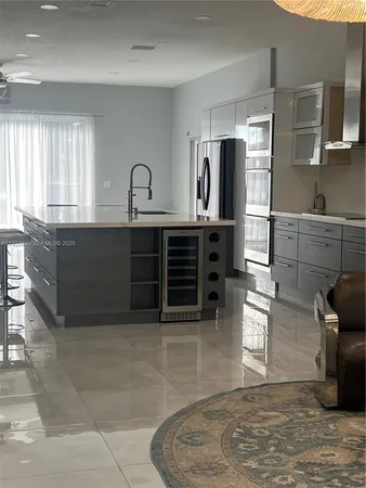 a kitchen with granite countertop a stove a sink and a refrigerator