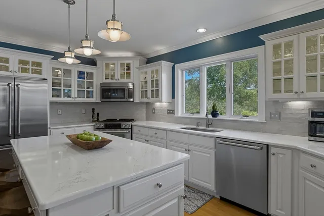 a kitchen with kitchen island granite countertop a sink and a stove