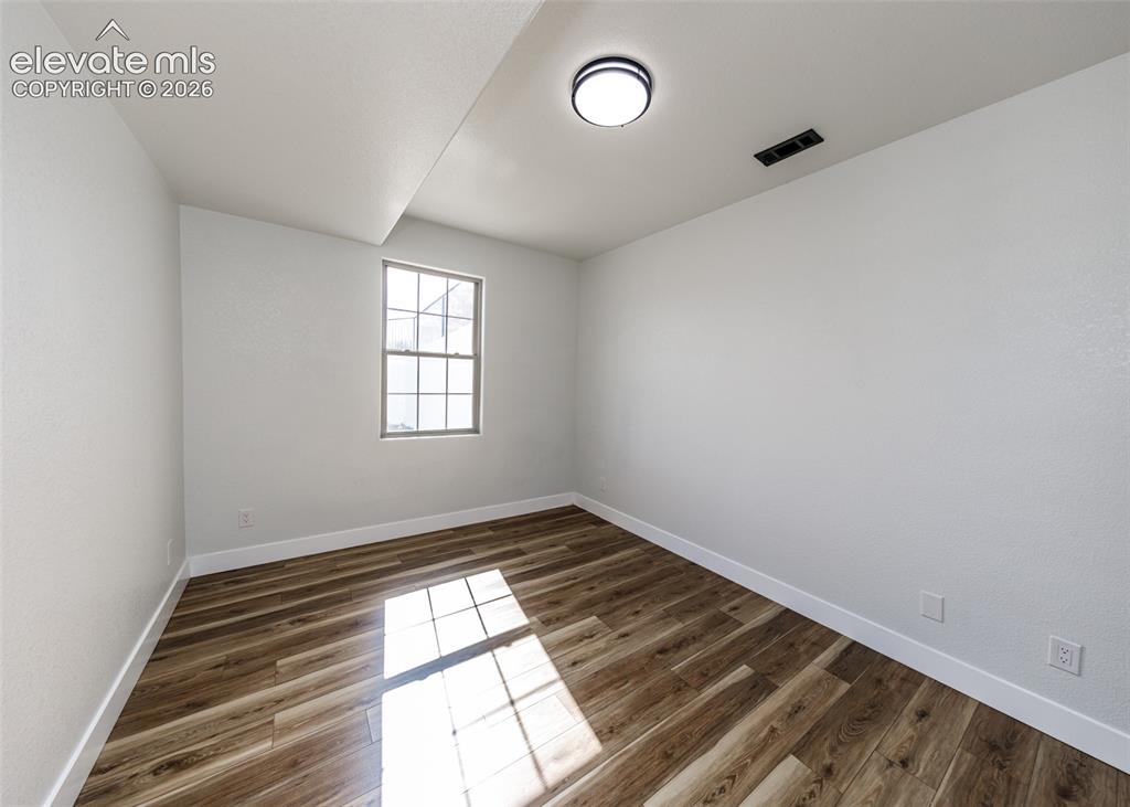 1120 Newton Road Pueblo, CO 81005 - Photo 31 of 46 an empty room with wooden floor and windows