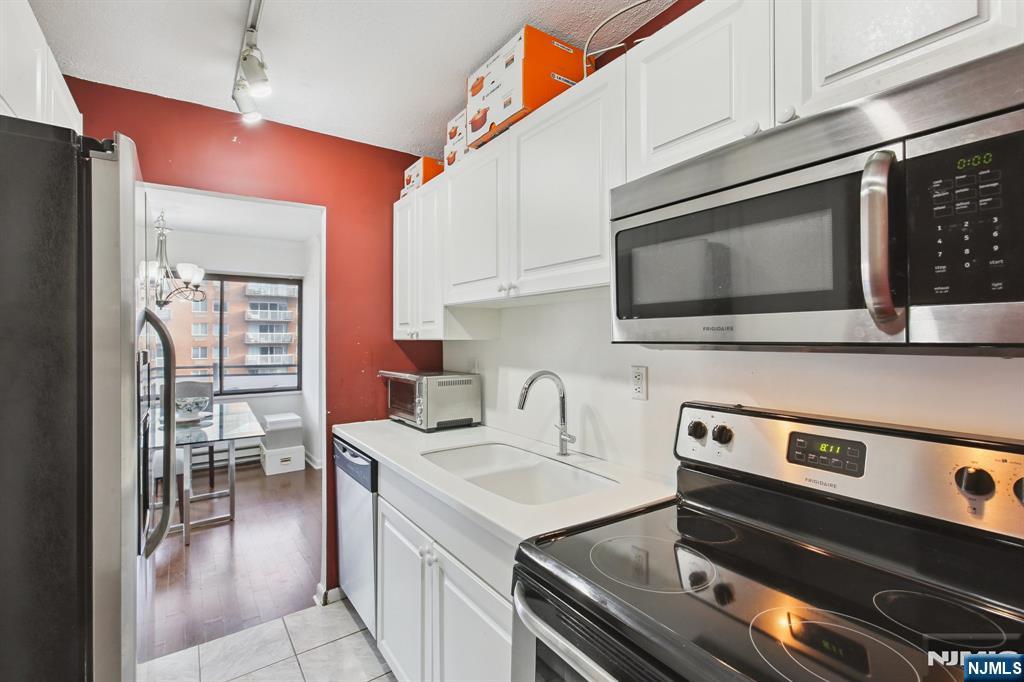 125 Prospect Avenue, Unit 17G Hackensack, NJ 07601 - Photo 14 of 20 a kitchen with stainless steel appliances a stove a sink and a microwave