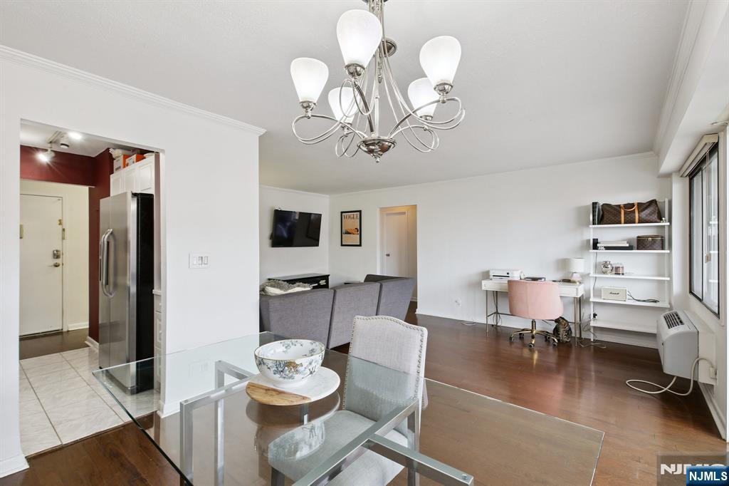 125 Prospect Avenue, Unit 17G Hackensack, NJ 07601 - Photo 8 of 20 a view of a dining room with furniture a chandelier and wooden floor