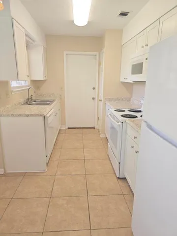 a kitchen with a sink a stove a refrigerator and cabinets