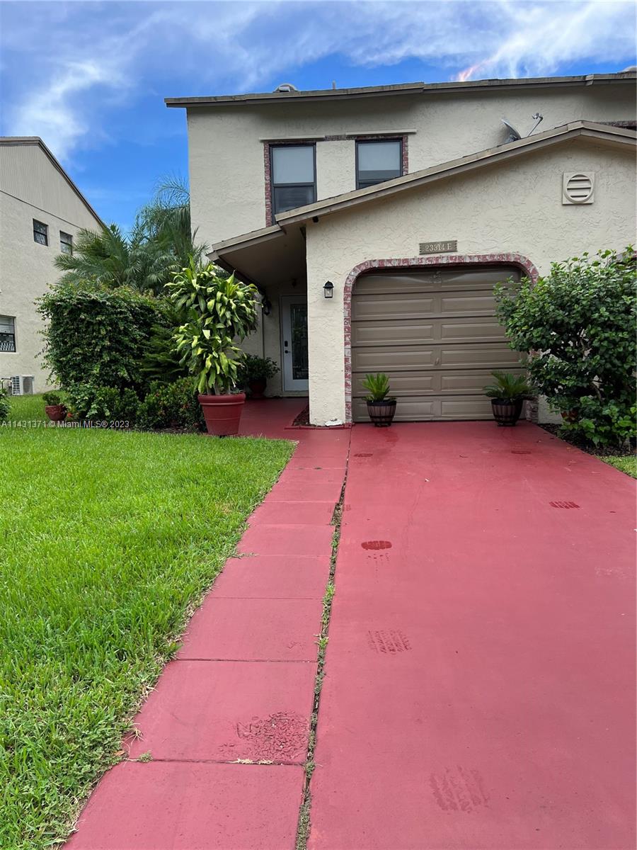 23314 Southwest 54th Way, Unit E Boca Raton, FL 33433 - Photo 13 of 69 a front view of a house with a yard and garage
