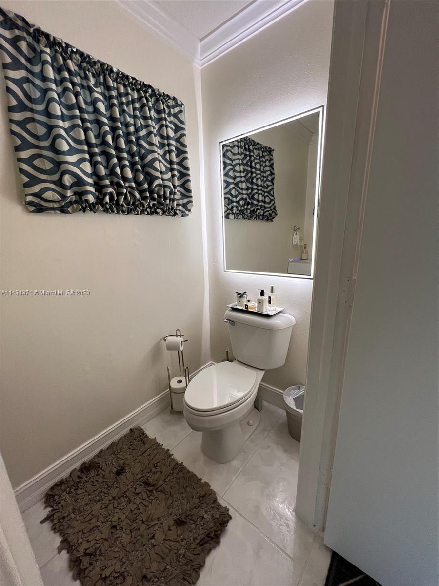 23314 Southwest 54th Way, Unit E Boca Raton, FL 33433 - Photo 33 of 69 a bathroom with a toilet a sink and a window