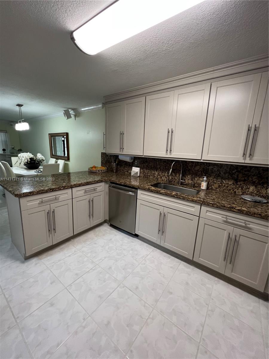 23314 Southwest 54th Way, Unit E Boca Raton, FL 33433 - Photo 38 of 69 a kitchen with stainless steel appliances granite countertop a sink and cabinets