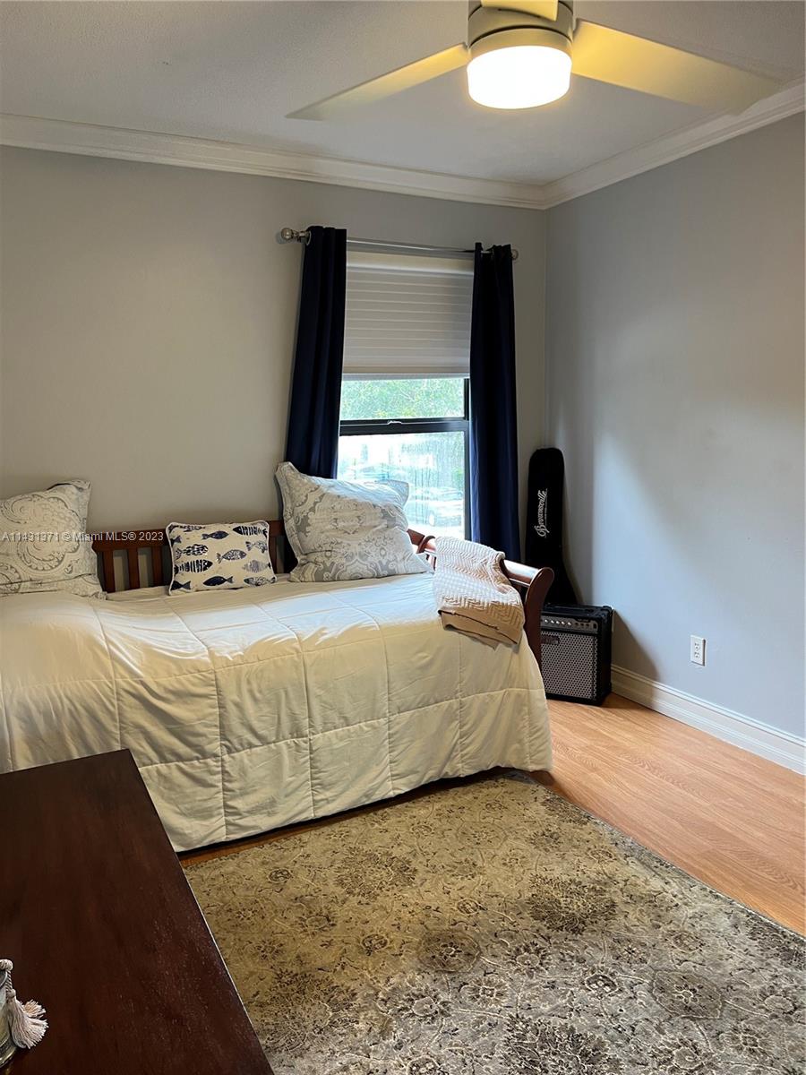 23314 Southwest 54th Way, Unit E Boca Raton, FL 33433 - Photo 57 of 69 a bedroom with a bed and a chandelier