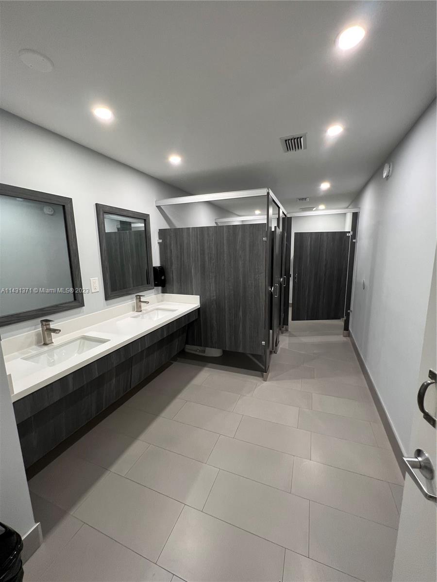 23314 Southwest 54th Way, Unit E Boca Raton, FL 33433 - Photo 10 of 69 a large bathroom with a double vanity sink and mirror