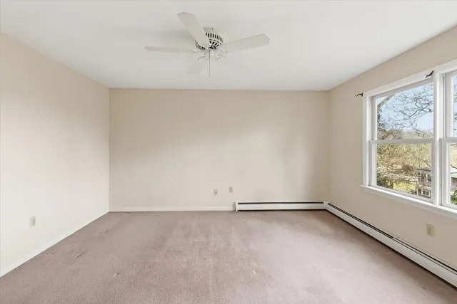 an empty room with a window and a ceiling fan