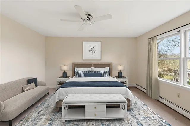 a bedroom with a large bed couch and a window