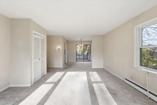a view of hallway with windows and chandelier