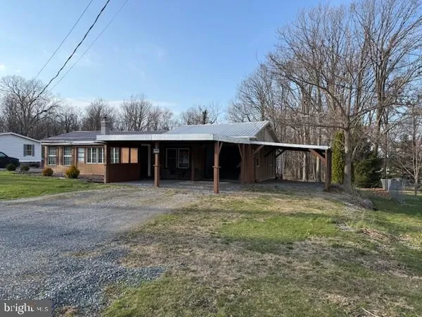 a view of a house with backyard and trees