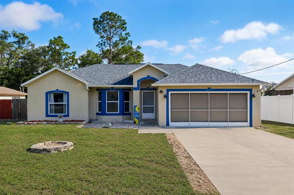 10303 Fordham Street Spring Hill, FL 34608 - Photo 1 of 25 a front view of a house with a garden and yard