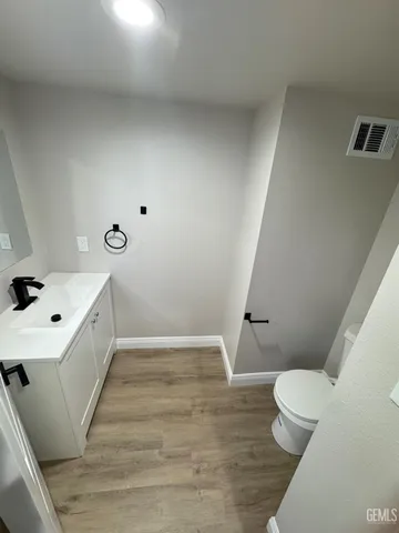 a bathroom with a sink mirror vanity and toilet