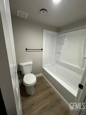 a white toilet sitting next to a bath tub
