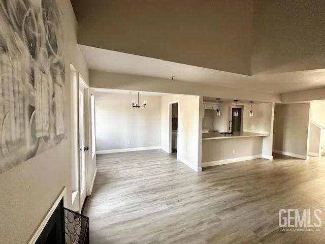 a view of a hallway with wooden floor and a living room