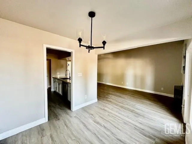 a view of a room with wooden floor a ceiling fan and a window