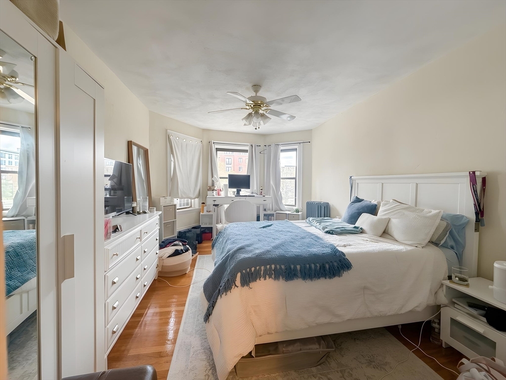 1472 Commonwealth Avenue, Unit 2 Boston, MA 02135 - Photo 16 of 16 a bedroom with a bed a large window with table and chairs