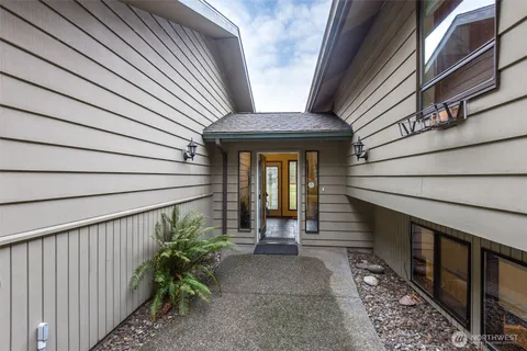 a view of a house with wooden floor and floor to ceiling window with wooden fence