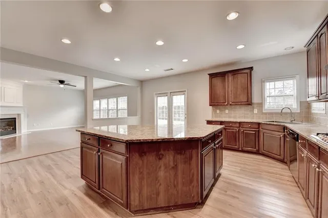 a kitchen with stainless steel appliances granite countertop a stove a sink and a granite counter tops with wooden floors